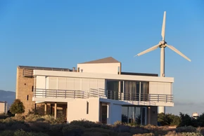 Maison moderne contemporaine à architecture cubique avec terrasse et balcons à garde-corps métalliques horizontaux