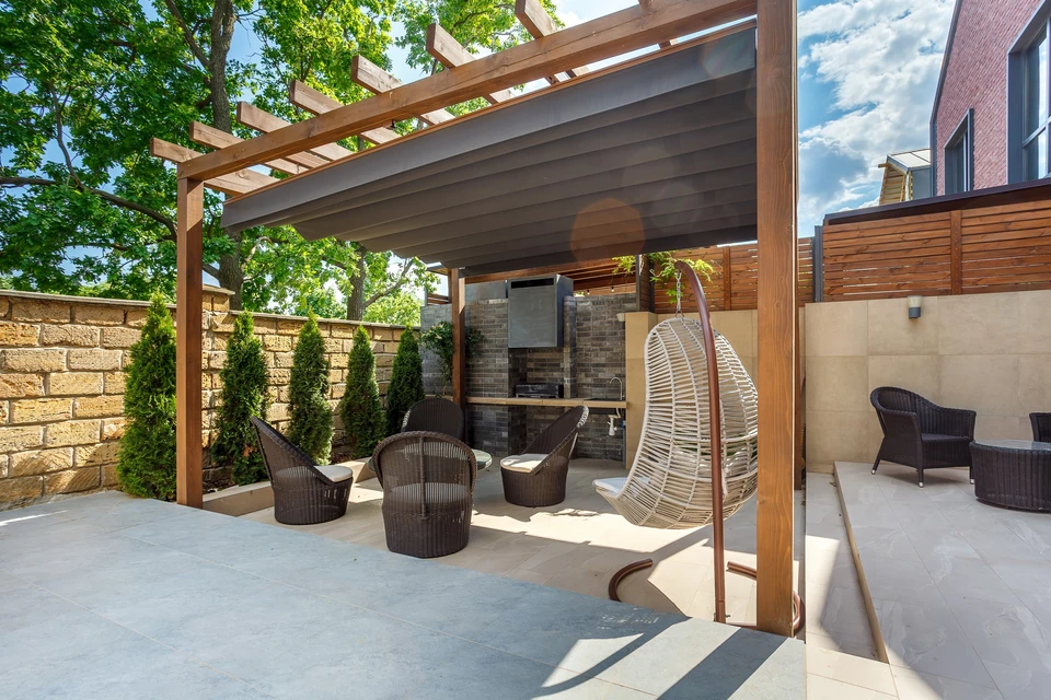Aménagement extérieur contemporain avec pergola en bois exotique à lames orientables et rideaux blancs