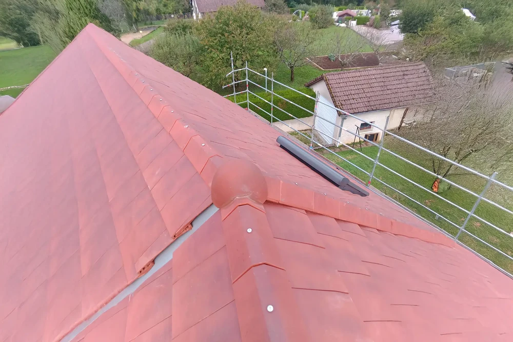 Maisons résidentielles avec installations de panneaux solaires photovoltaïques sur toitures en tuiles rouges, environnement pavillonnaire verdoyant sous ciel bleu