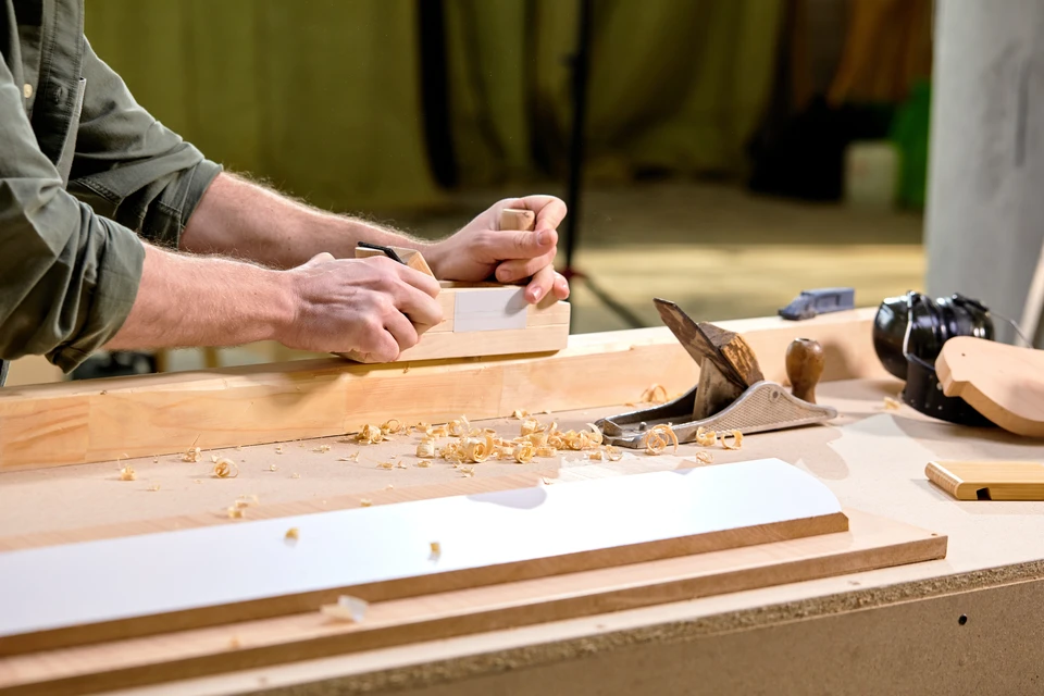 Chantier de construction d'une maison en bois massif empilé, structure en cours d'assemblage avec charpente apparente et ouvertures découpées