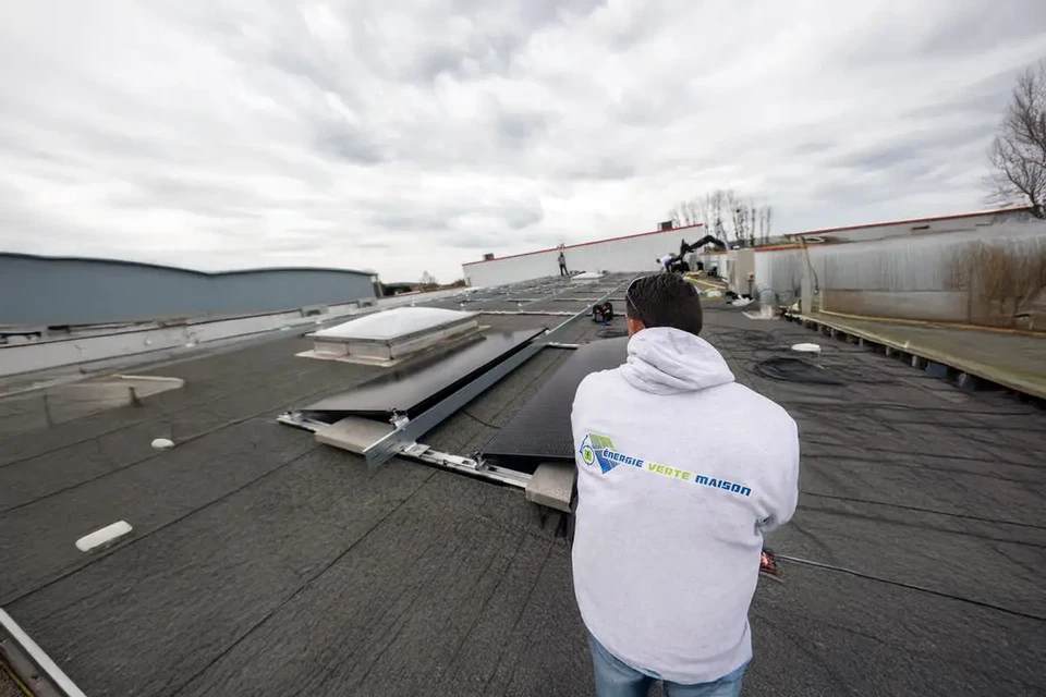 Maison contemporaine blanche à deux niveaux avec toiture en tuiles grises, située dans un environnement résidentiel verdoyant